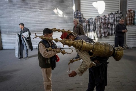 Damascus, Syria. December 5th 2025. A traditional Syrian juice seller serves a young boy in Souk Al