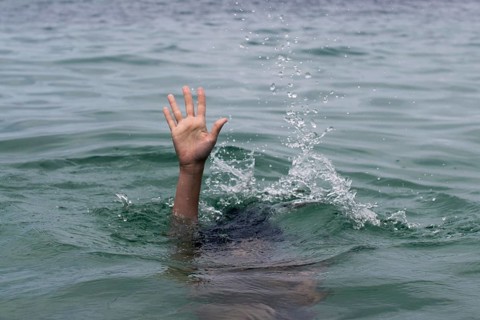 A hand emerges from turbulent water, reaching upward in a desperate plea for help. This dramatic