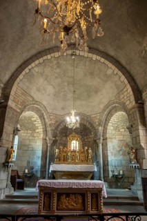 Auzon village. Interior of Saint Laurent Collegiate church featuring stone arches and an ornate