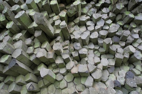 Basalt prism wall with columned basalt, grey square basalt stones, rods, rock formations, stone