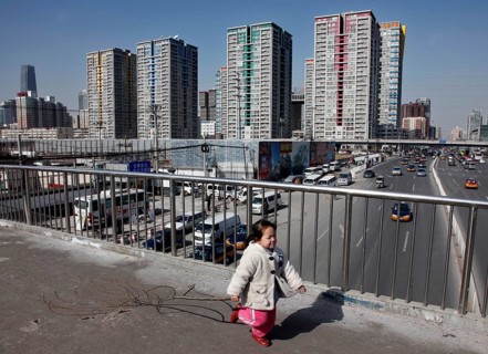 Beijing, CHN, 20.02.09 - A little girl plays on a footbridge on a busy street in Beijing, CHINA