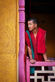 THIKSEY, INDIA, SEPTEMBER 13, 2012: Young Buddhist monk standing in doorway of of Thiksey gompa,