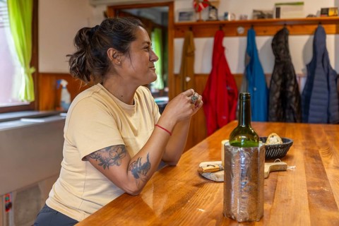 A woman sits in a cozy shelter in Gorbea Natural Park, Basque Country, Spain, enjoying a meal with