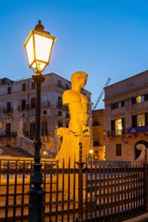 Statue close-up by night, Praetorian Fountain or Fontana Pretoria, Palermo, Sicily, Italy