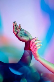 A visually striking image showcases multiethnic hands in an embracing pose, illuminated by vivid