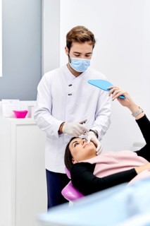 A doctor in a medical office administers a hyaluronic acid injection to a patient. The doctor wears