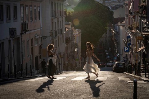 LISBON, PORTUGAL - MAY 20, 2025: Women taking a photoshoot with their smartphone at a pedestrian