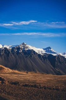 Crisp view of dramatic snow-covered peaks and dark rocky slopes in the highlands of Stokksnes,