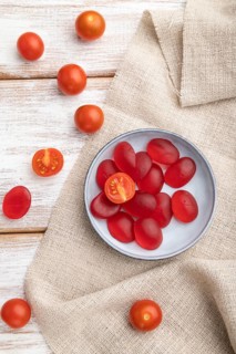 Jelly tomato candies on white wooden background and linen textile. close up, top view, flat lay
