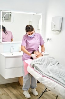 A skilled therapist provides a calming facial treatment to a client in a serene aesthetic medicine