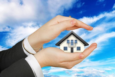 Two protective hands with single-family house, cutout, white background, cloudy sky, woman's hands,