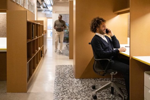 A modern coworking space in Barcelona showcases professionals engaged in various tasks. The