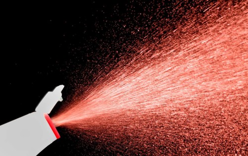 A fine spray of glass cleaner, colored against black background
