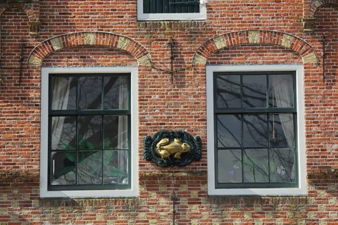 House façade with two windows and frog figure, brick house, Den Burg, Texel, North Holland,