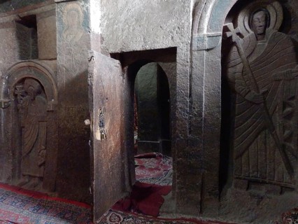 A room with stone reliefs and a slightly open door in a sacred context, UNESCO World Heritage Site,
