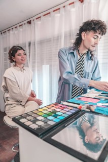 Professional makeup artist applying makeup on a model in a beauty salon, using a colorful eyeshadow