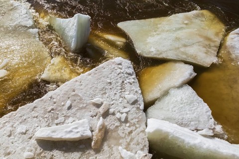 Close-up of large blocks of thick jagged ice floes floating on the surface of the Mille-Iles river