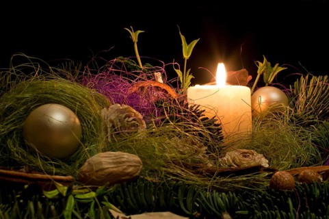 Christmas decoration with a burning candle on a black background in Poland
