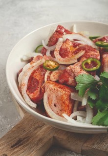 Raw meat marinated with spices and onions, for barbecue, sliced meat, pork neck, in a bowl,