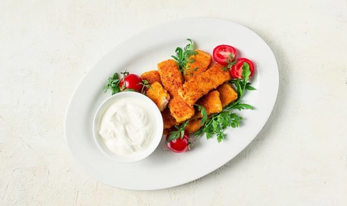 Fried fish nuggets, with white sauce, arugula and cherry, no people