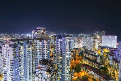 A stunning nighttime view of Batumi, Georgia, showcasing illuminated high-rise buildings and