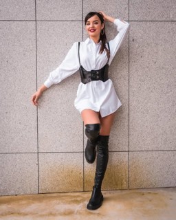 Young caucasian girl with white shirt and black leather boots. Enjoying holidays in the city,