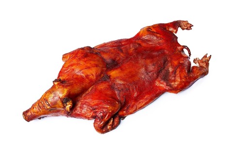 Baked, fried piglet on a wooden table, without people, on a white background