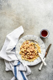 A delectable chifferi rigati pasta dish garnished with fresh herbs, and a light sauce. Served on a