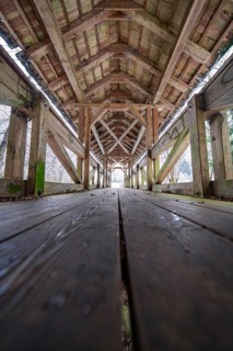 Interior view of a snow-covered wooden bridge with symmetrical structures, Kälberbrücke,
