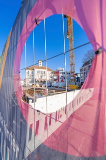 View through a colourful fence onto a construction site and buildings, Sindelfingen, Böblingen