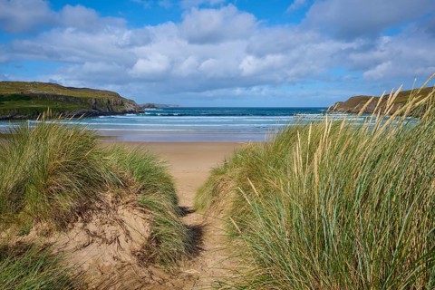 A sandy path leads through the dunes to a wide, wavy beach, Farr Bay, Bettyhill, Thurso, Scotland,