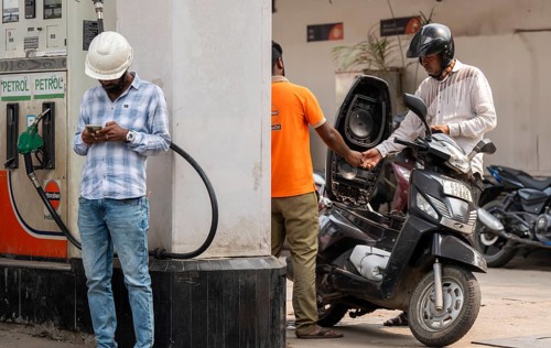 A fuel station attendant refuels a motorcycle at a petrol pump in Guwahati, India, on March 11,