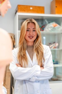 Portrait of a confident medical student standing with crossed arms in a university laboratory,