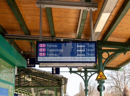 S-Bahn platform with historic structures and the display board for the train connections at