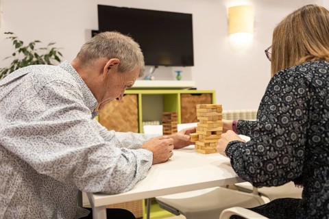 Couple with intellectual disabilities engage in a fun game of Jenga, focusing intently as they