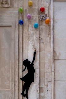 Colourful ceramic balloons and a girl figure as decoration on a house facade, Martina Franca,