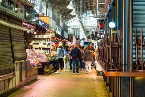 Market stalls with visitors in the Mercat de la Boqueria, famous market on the Ramblas in