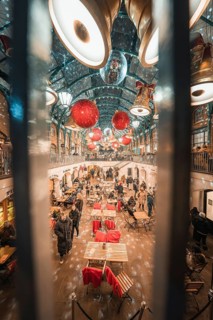 View through bars of a festively decorated market hall with set tables, AppleMarket, London, Great