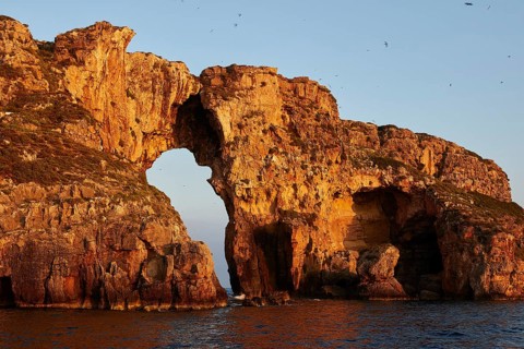 Stone bridge in dramatic sunrise light over the sea, morning light, Tsichli Babas islet, Navarino
