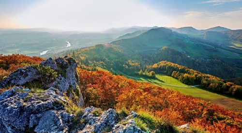 View of an autumnal forest from the Gisliflue, behind the Jura foothills with Wasserfluh and
