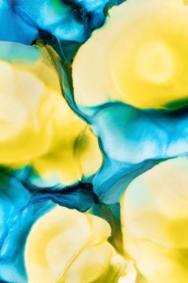 Vivid abstract art featuring flowing inks in shades of blue, teal, and yellow, creating a