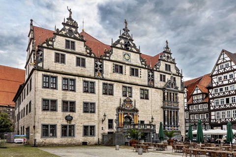 Historic square with monumental buildings and half-timbered houses under a cloud cover, The
