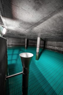 Cavity with blue water and metallic inlet funnel, ENCW Netze Calw waterworks, Calw, Black Forest,