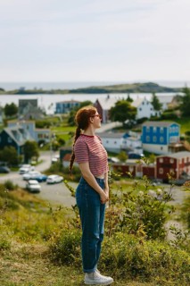 Side view of a red hair woman, captured from the side with a peaceful stance, gazes over the