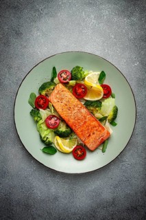 Grilled salmon fillet, with vegetables, broccoli, cherry, iceberg lettuce, spices and herbs,