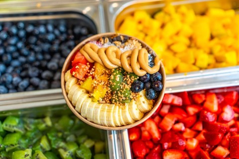 Acai smoothie bowl with vibrant sliced banana, mango, kiwi, strawberries and blueberries, topped