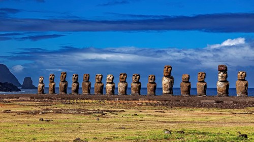 Moai statues on a grassy plain overlooking the sea under a cloudy sky, The Moai statues on Easter