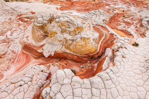 Captivating aerial view of abstract red and white rock formations in a desert landscape, showcasing
