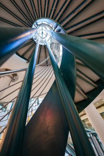 Dramatic perspective on a spiral staircase with a modern metal and glass design, Sterncenter