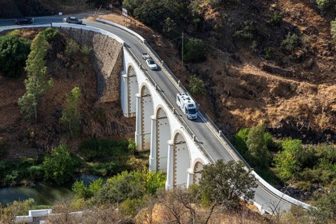 Campervan on bridge Ponte de Mertola, crossing river Guadiana, village Mertola, Portugal
